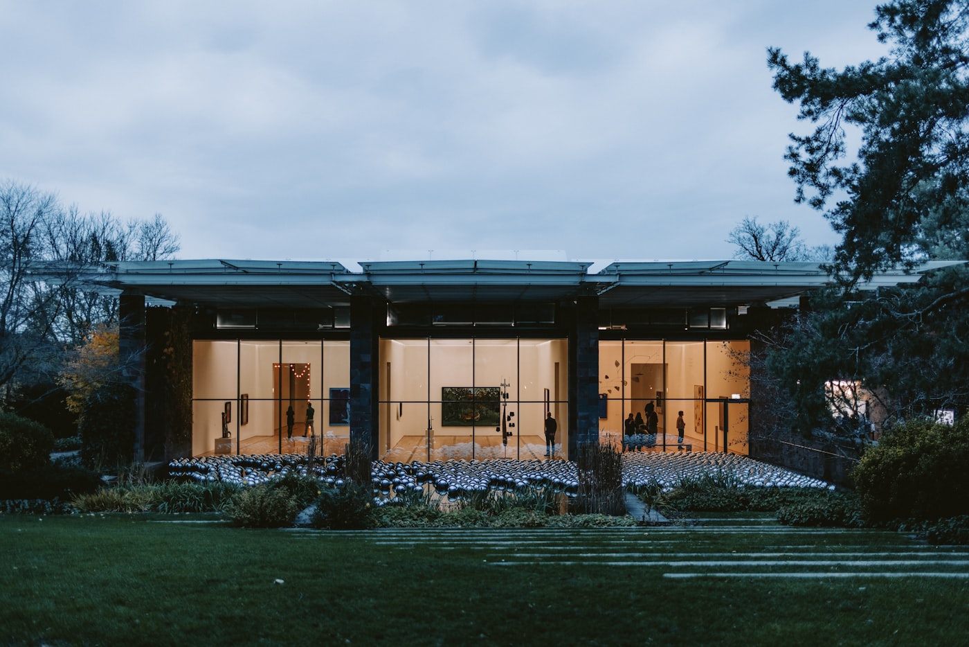 Clubhouse: glass pavilion glowing at dusk